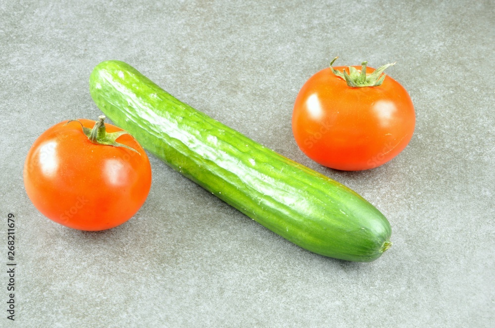 cucumber and tomatoes on a gray background cucumber and tomatoes on a gray background