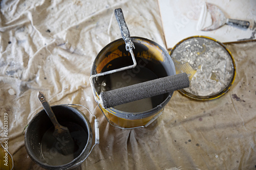 overhead of painter's tools, brushers, rollers and paint tins