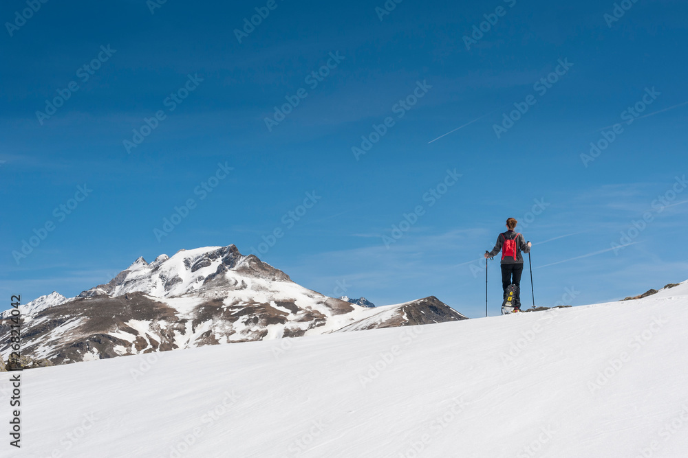 A young snowshoe hiker walks through a snowy alpine landscape.