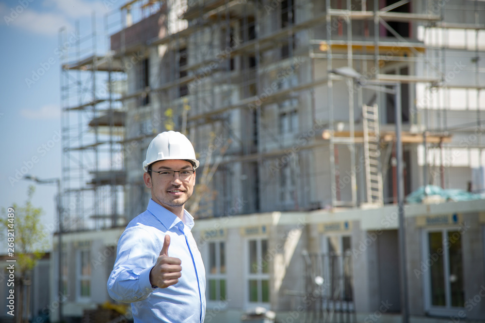 Architect at the construction site shows thumbs up.. Architect at the construction site shows thumbs up..
