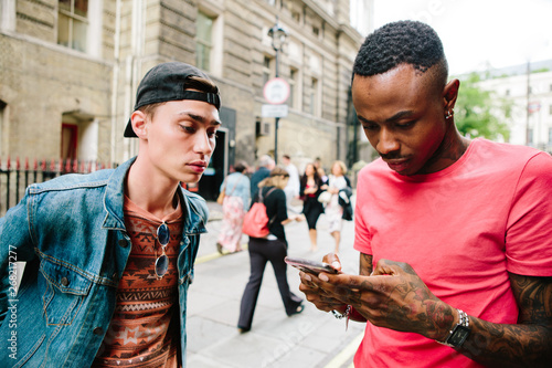 Two young men using a mobile phone photo