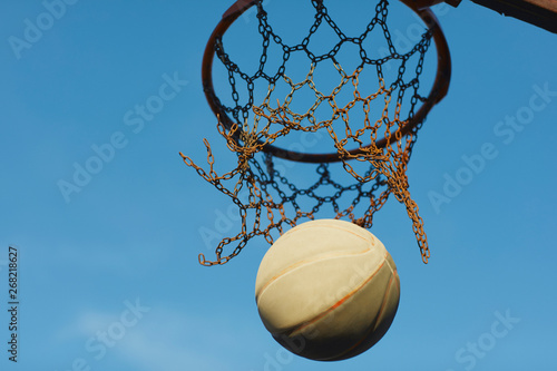 Low angle view of basketball falling from basketball hoop photo