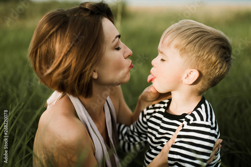 Mother kiss her little son outdoor