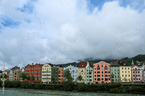 The Innstrasse (Inn street) in Innsbruck in Austria with its typical colorful houses with the cloudy sky behind.