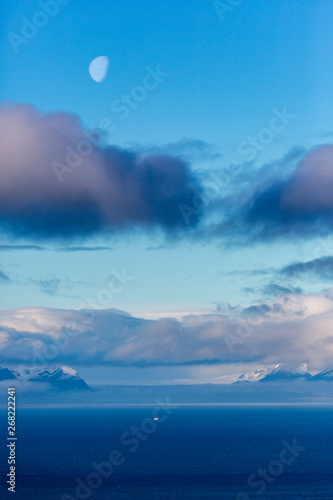 View across Isfjord in Svalbard, Blue water with boat and glaciers in the background, Halfmoon, Svalbard, Spitsbergen, Norway photo