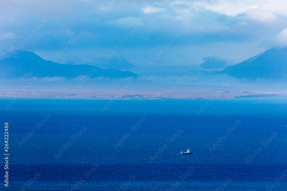 View across Isfjord in Svalbard, Blue water with boat and glaciers in the background, Svalbard, Spitsbergen, Norway