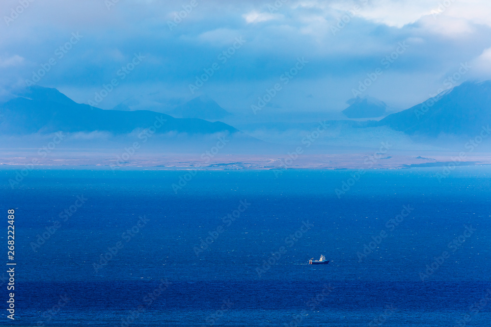 View across Isfjord in Svalbard, Blue water with boat and glaciers in the background, Svalbard, Spitsbergen, Norway View across Isfjord in Svalbard, Blue water with boat and glaciers in the background, Svalbard, Spitsbergen, Norway