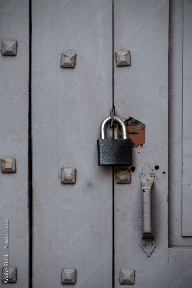 padlock on an old wooden door with wrought nails hats padlock on an old wooden door with wrought nails hats
