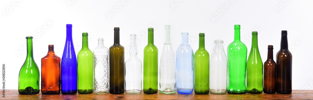 several bottles on top of a wooden table with a white background several bottles on top of a wooden table with a white background