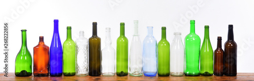 several bottles on top of a wooden table with a white background