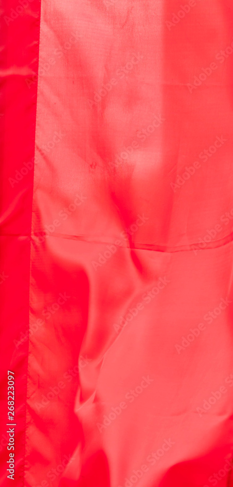 Red silk flag waving in the wind pattern fabric vintage style background texture Red silk flag waving in the wind pattern fabric vintage style background texture