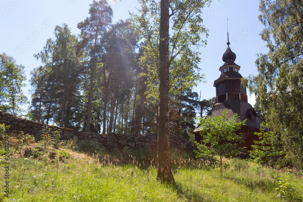 Forest landscape with an old wooden church of the 18th century on the island of Seurasaari in Helsinki in Finland, summer day.