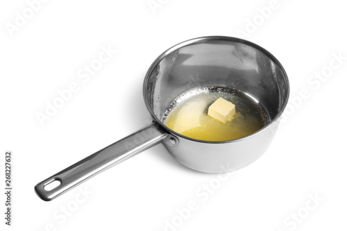 Saucepan with melting butter on white background