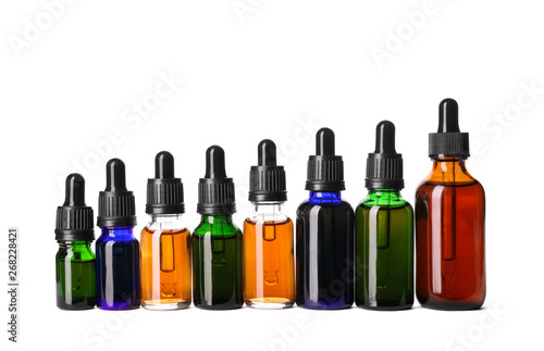 Cosmetic bottles of essential oils on white background