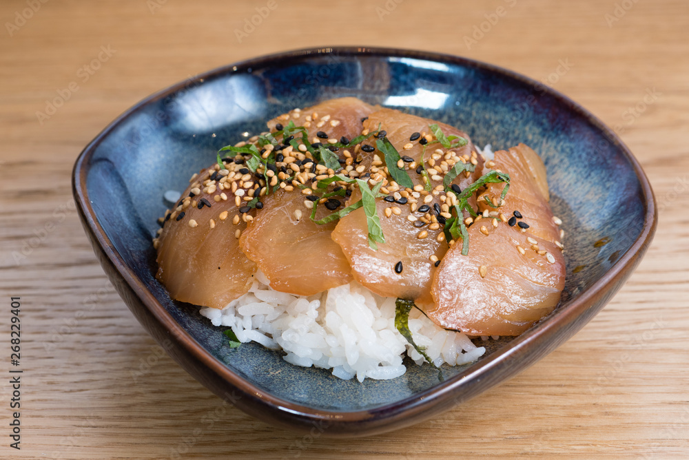 bowl with salmon sashimi seasoned with black and white sesame, rocket, nori seaweed fried on a bed of steamed white rice bowl with salmon sashimi seasoned with black and white sesame, rocket, nori seaweed fried on a bed of steamed white rice