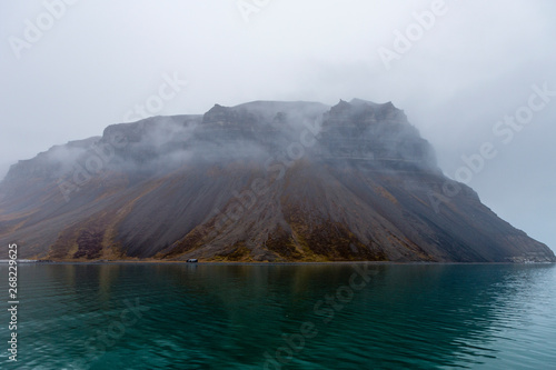 Boot trip at Isfjord direction Pyramiden, mystic fog around mountains, Svalbard, Spitzbergen, Norway