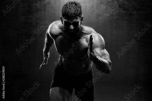 Muscular Men in Running Motion. Handsome Male Athlete Sprinting photo