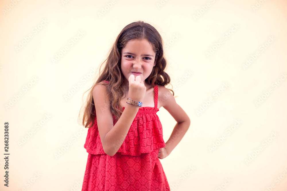Little angry girl shows fist at camera. Children and emotions concept