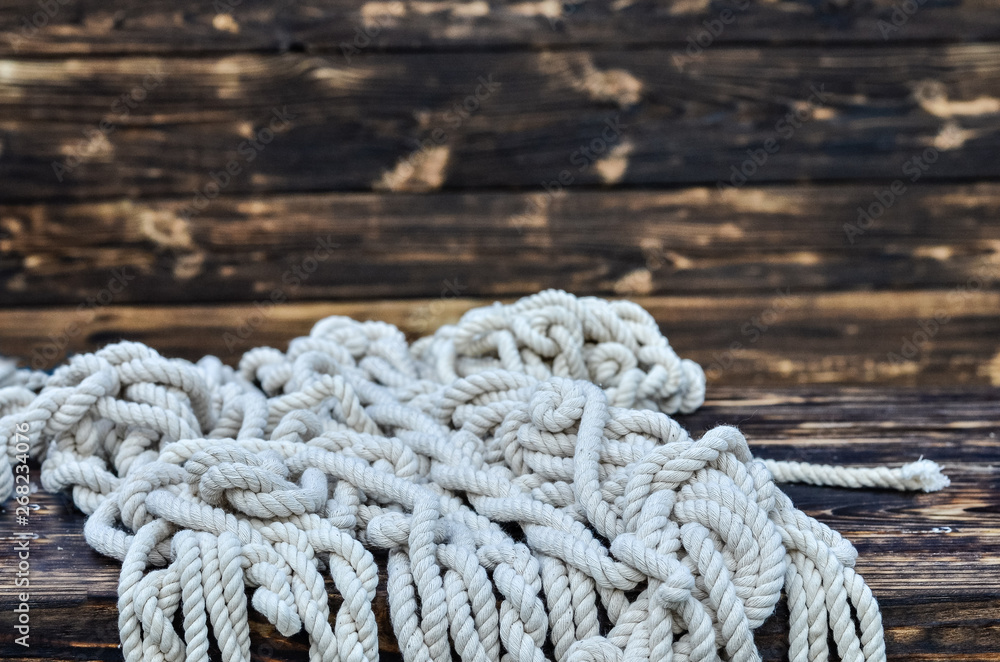 Fototapeta premium Ship rope on rustic wooden background. Copy space.