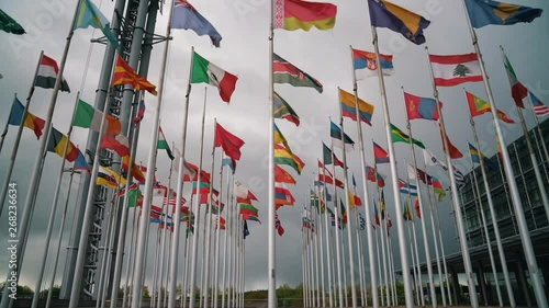  International flags of different countries waving in the wind on flagpoles - Ukrainian, Norway, Poland, Canadian, Georgian, Armenian, Lithuanian, Austrian and more
