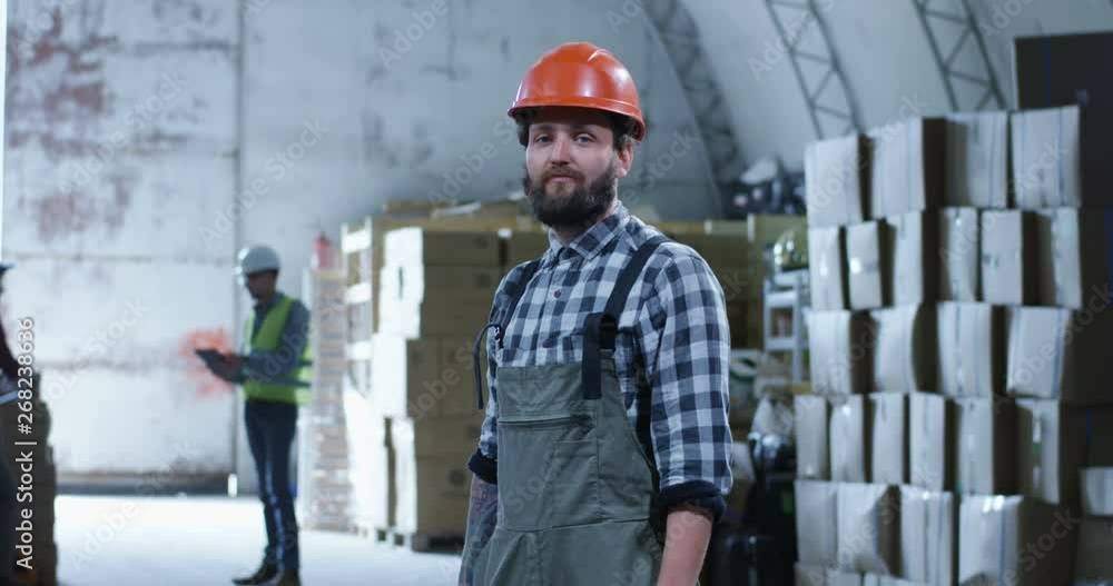 Worker smiling into camera in a warehouse