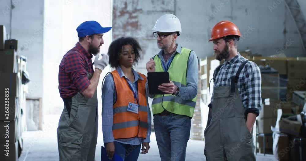 Engineer giving out instructions in a warehouse Engineer giving out instructions in a warehouse