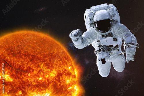 Fototapeta Naklejka Na Ścianę i Meble -  Astronaut in outer space with Sun of solar system. Science fiction wallpaper. Elements of this image were furnished by NASA.