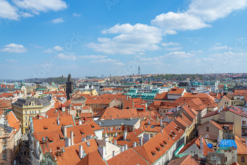 Aerial panoramic top view above old town and city skyline with famous attraction; The Powder and Henry's Tower and Television Tower against blue sky on sunny day in summer in Prague, Czech Republic.