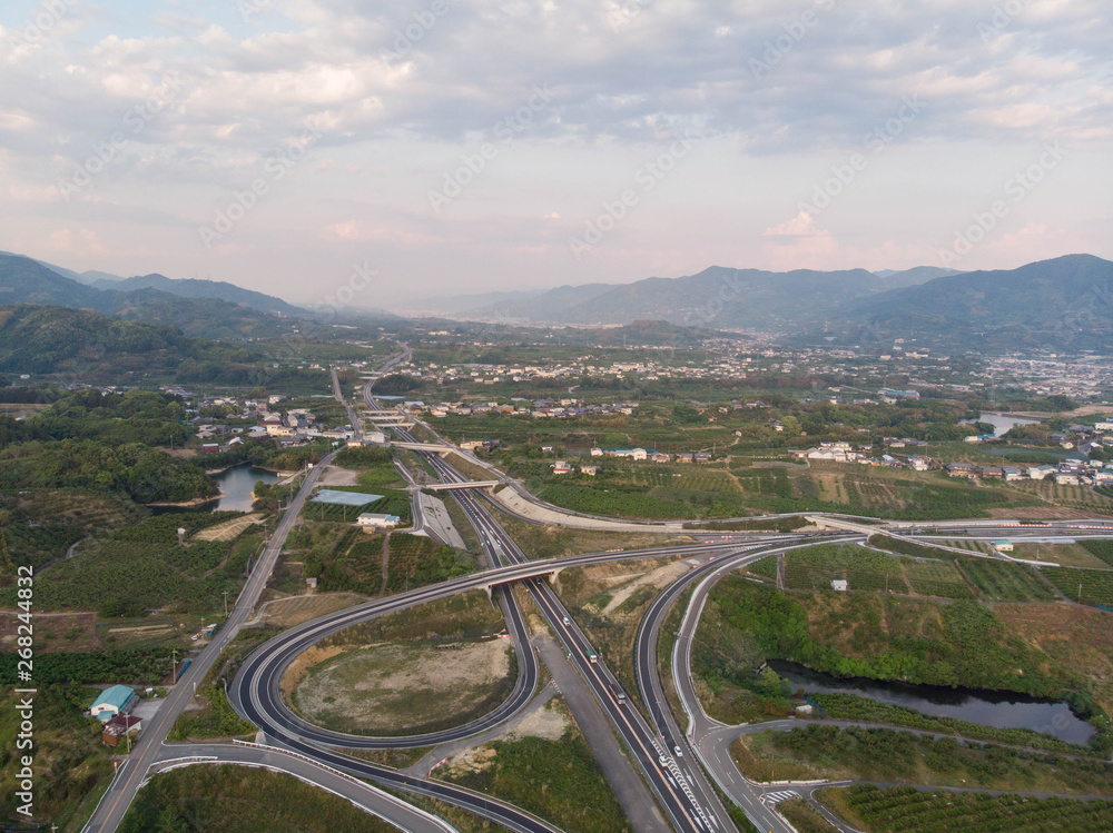 Aerial view of rural expressway with mountains and clouds in the distance