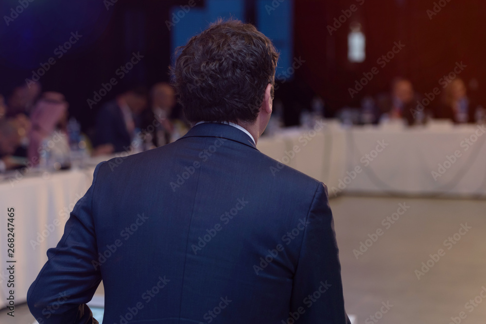 Young businessman at business conference room with public giving presentations. Audience at the conference hall. Entrepreneurship club. Young businessman at business conference room with public giving presentations. Audience at the conference hall. Entrepreneurship club.