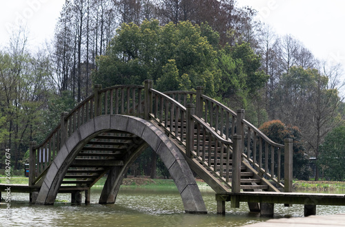 Wooden bridge in the park at the part of Wuhan Botanic garden.