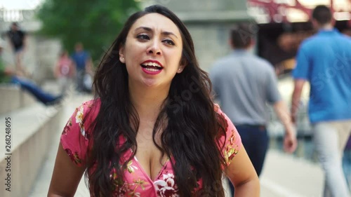 Wallpaper Mural  Young Latina woman  talking head is at Chicago River Walk  having an exciting conversation and happy showing many facial expression while moving hair.  wearing pink blouse Torontodigital.ca