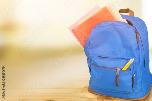 Open blue school backpack and school desk with text and formulas