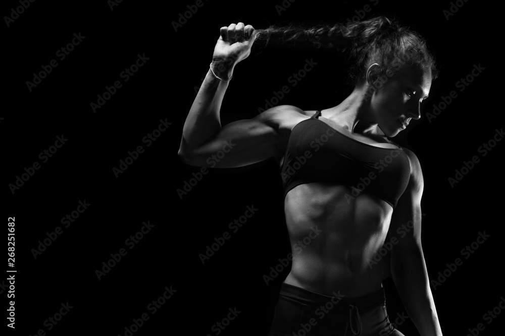 Fit athletic sporty woman posing on black background Fit athletic sporty woman posing on black background