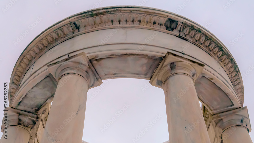 Clear Panorama Looking up at a white circular structure supported by smooth columns
