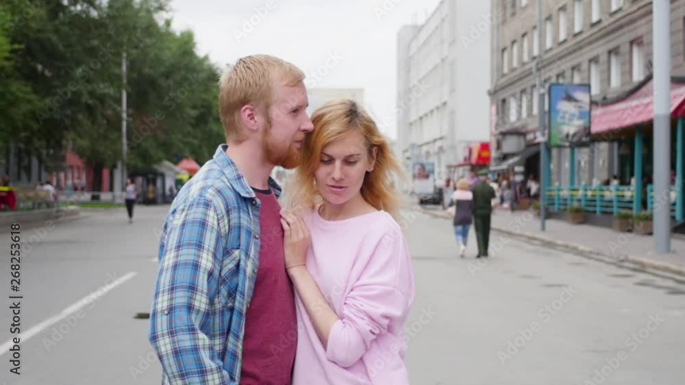 Young couple in love, hugging on the street. Selective focus. woman and man stand on the background of the city Young couple in love, hugging on the street. Selective focus. woman and man stand on the background of the city