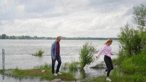 Young couple in love on the background of the river. a woman and a man are standing against the background of the forest hugging. husband and wife walk in nature. photo