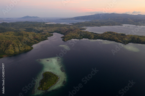 Seen from a bird's eye view, dusk settles over Rinca Island in Komodo National Park, Indonesia. This tropical area is known for its marine biodiversity as well as its dragons.