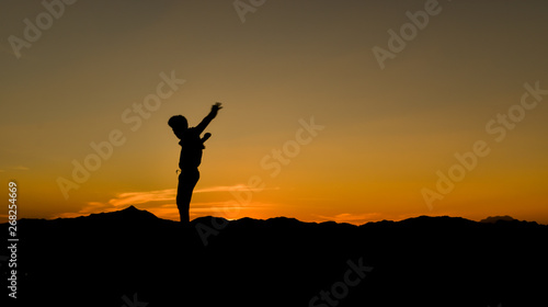Silhouette of a jumping man at sunset, Concept lifestyle freedom vacation travel.