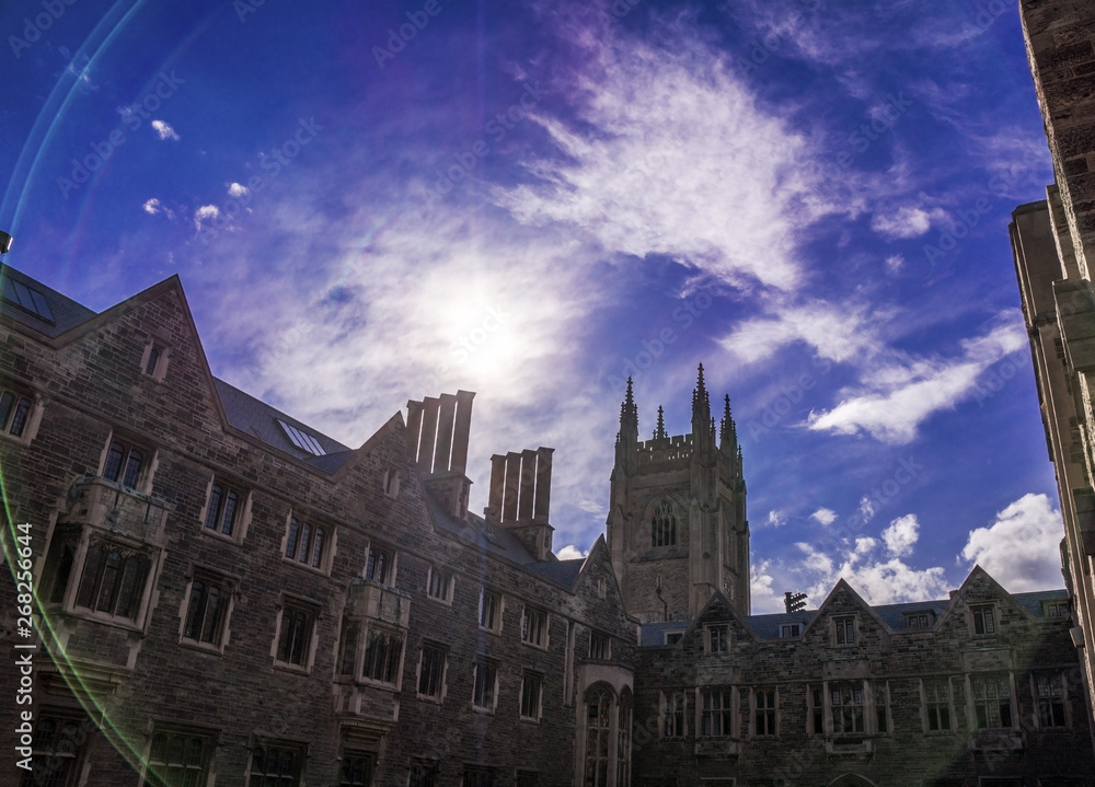 Toronto, Canada - 20 10 2018: Hart House building before bright blue sky with shiny sun and white clouds. Hart House is University of Toronto centre for experiential education outside the classroom