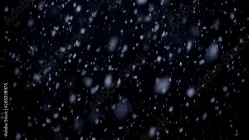 Falling snow in the night, snowflakes with black background in winter. photo