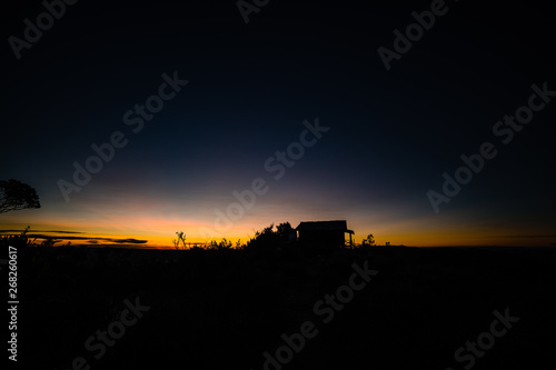 Silhouette of a cottage on the summit of a moor in Colombia during the sunrise
