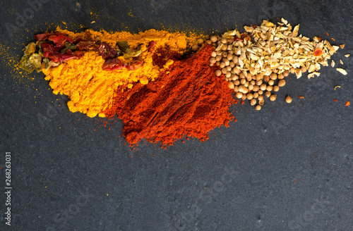 Different kind of spices on a black stone background