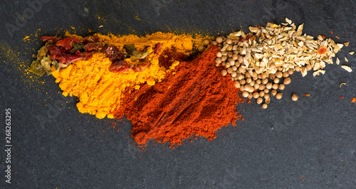 Different kind of spices on a black stone background