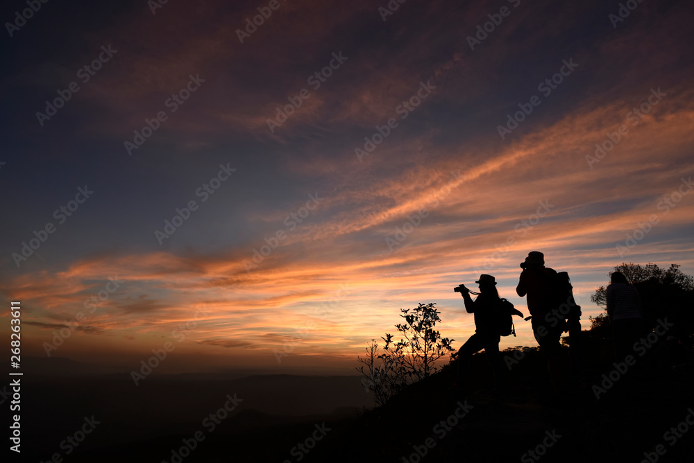 Two photographers silhouette are standing on a cliff with colorful twilight sky in an evening, Thailand