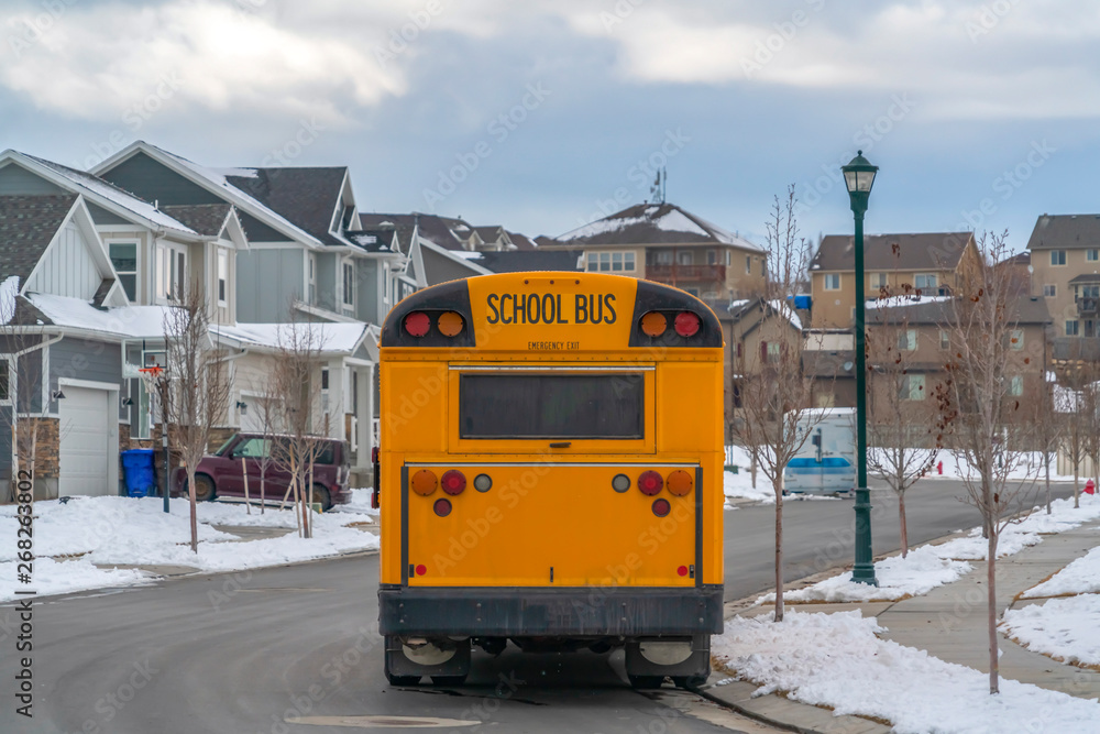 Rear view of a yellow school bus with a window and several signal lights