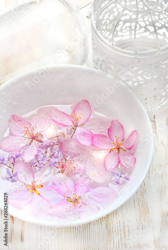 Spa concept. flowers in plate. Spa concept of blooming flowers. Bowl of aroma spa water and spring blossoming pink apple tree flowers, petals in water drops. close up. soft selective focus
