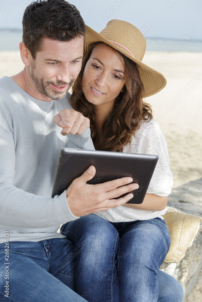 portrait of a happy couple using tablet computer outdoors portrait of a happy couple using tablet computer outdoors