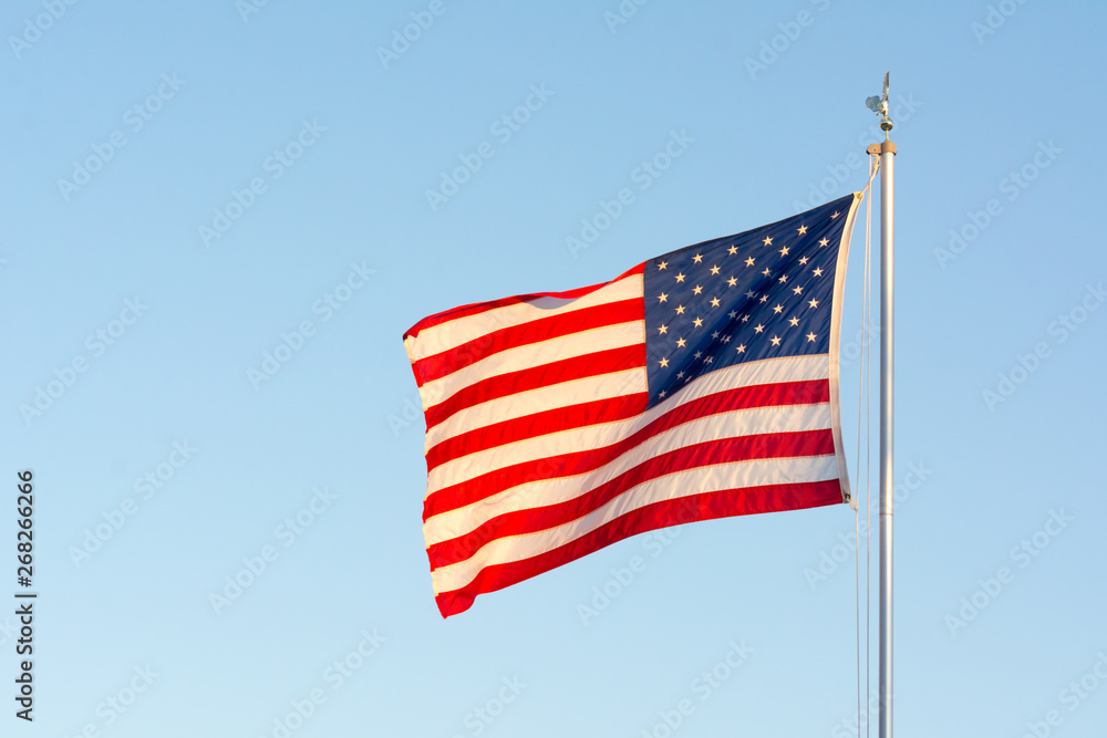 American National Flag Flitting in the Wind on Blue Sky BAckground