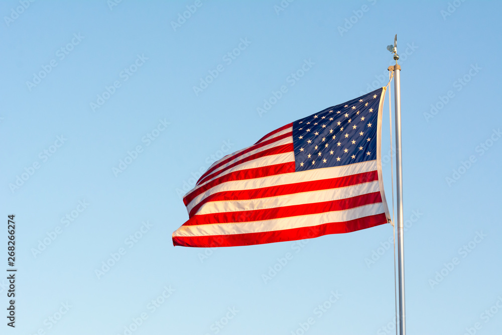 American National Flag Flitting in the Wind on Blue Sky BAckground